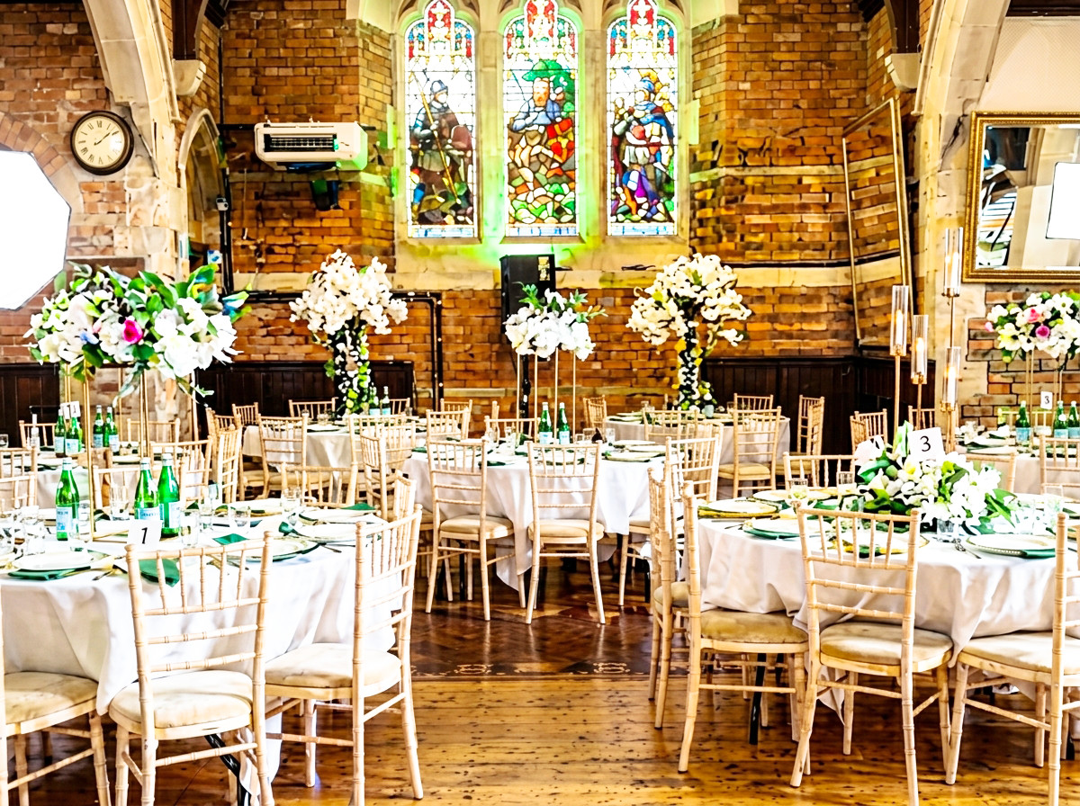Stained glass hall with tall floral arrangements